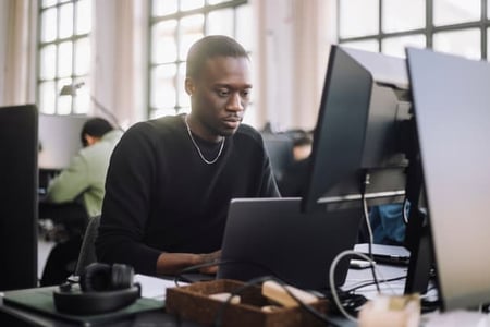 Person looking at computer learning about best WordPress themes. 